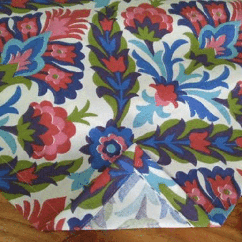 Primer plano de mantel de flores con colores rojo, azul, verde y celeste