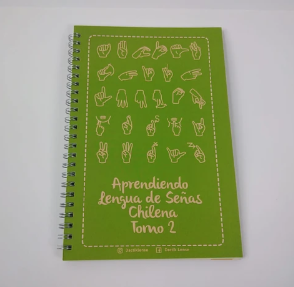 Foto de la portada del libro que dice Aprendiendo Lengua de Señas Chilenas Tomo 2, y arriba hay íconos de manos haciendo señas. 